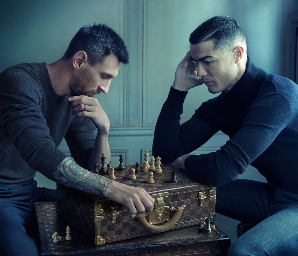 Messi e Cristiano Ronaldo jogam xadrez em cima de uma mala, em peça de campanha publicitária