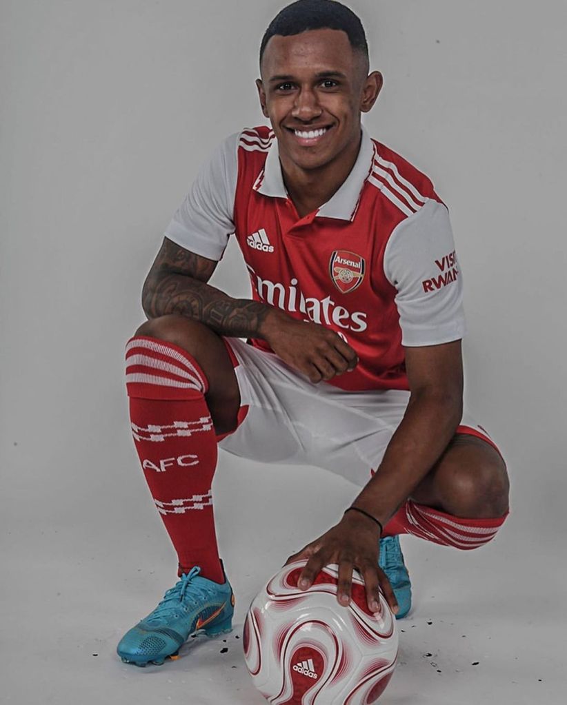 Marquinhos posa com uma bola de futebol vestido com o uniforme do Arsenal